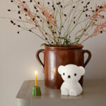 BORIS Bundle of Light Bären-Nachtlicht von Mr. Maria neben eine Kerze und Blumen
