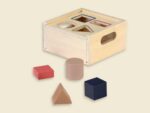 Formensortierbox aus Holz von Egmont Toys mit vier geometrischen Formen in Natur, Beige, Rot und Marineblau.